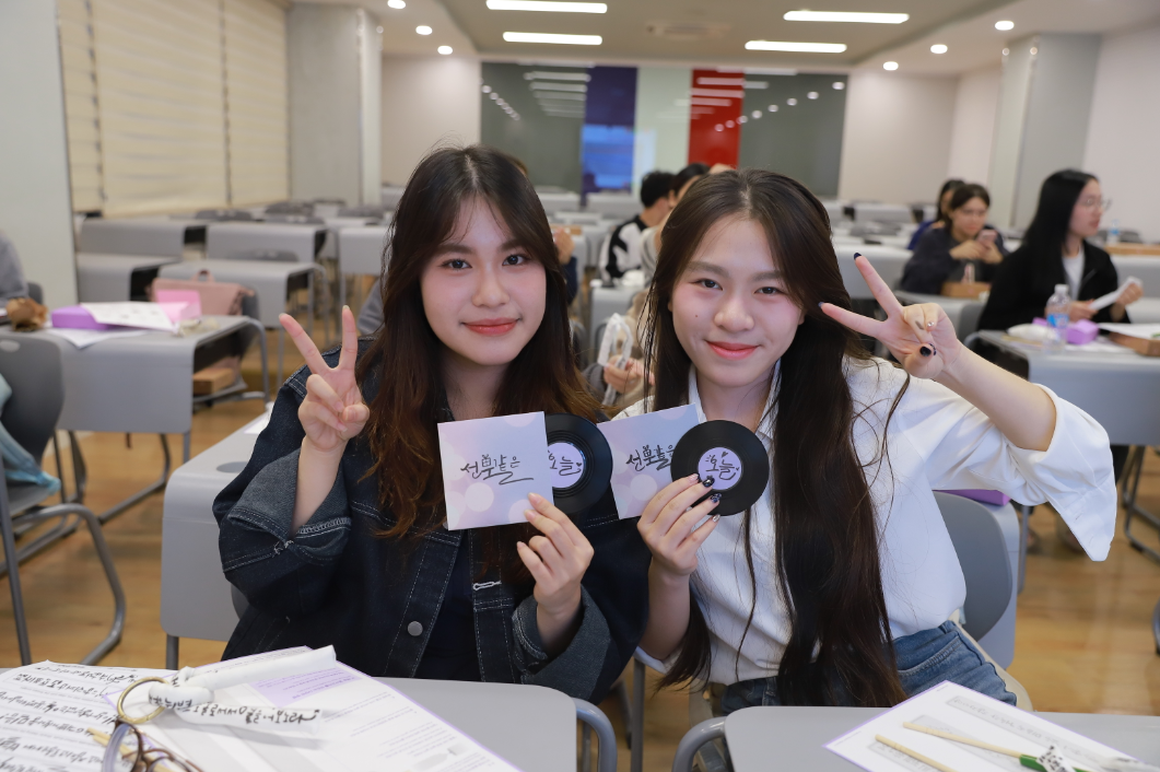 한국탐구동아리(KDC) 소속 대학생 2명은 만든 작품과 사진을 찍는다.