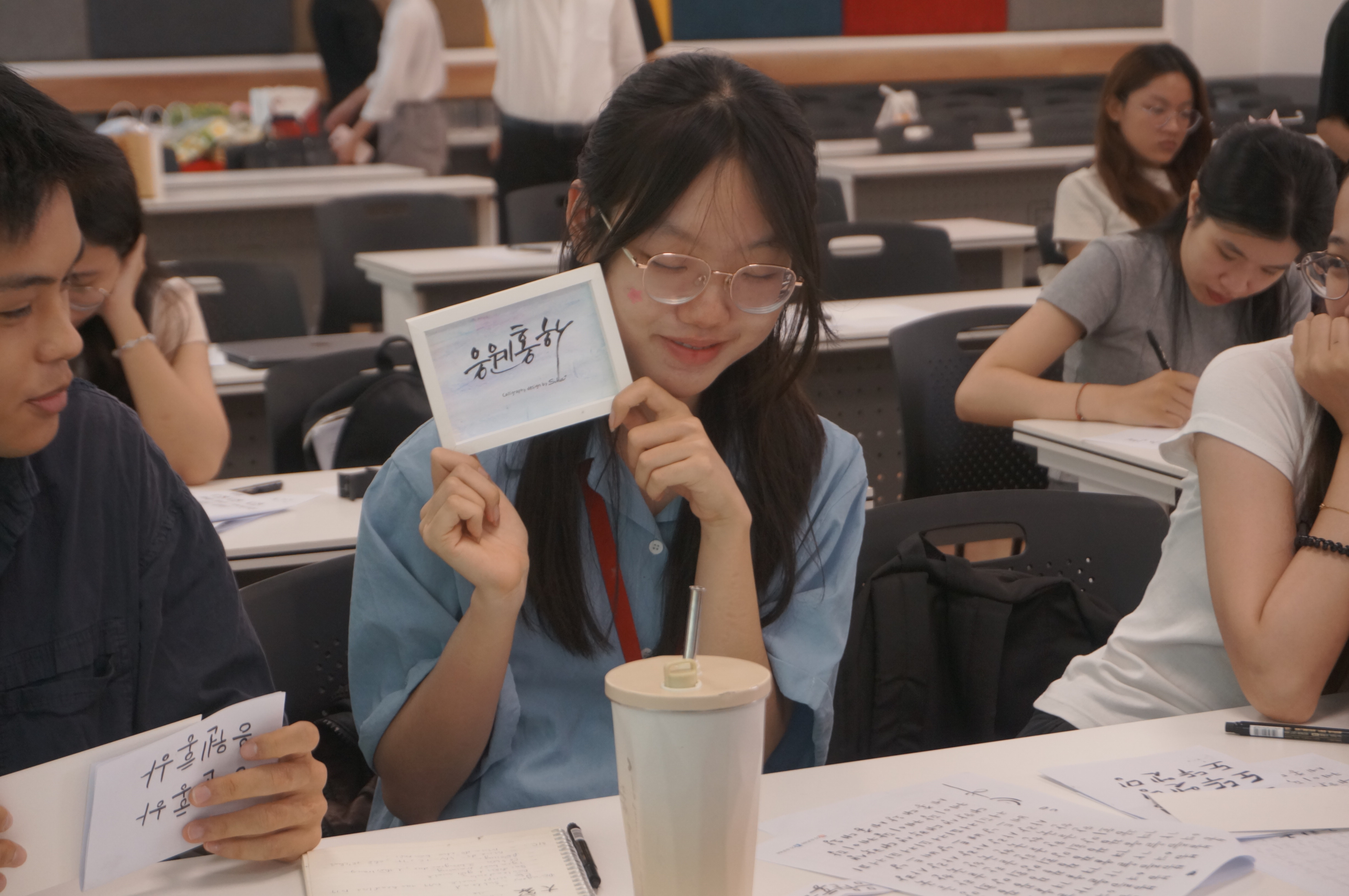 만들어 본 작품과 사진을 찍는 학생